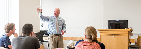 Brother Watson demonstrates water filtration to his students.