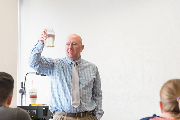 Brother Watson demonstrates water filtration to his students.