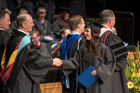 Faculty members hand degrees to and congratualate graduates of the College of Performing and Visual Arts.