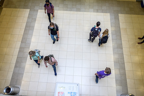 Student volunteers show the way to stay safe during this COVID 19 pandemic by social distancing, following pathway arrows and proper wearing of masks .