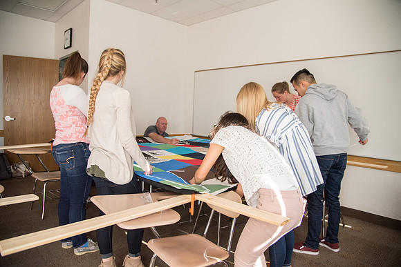 Brother Tyler Watson leads students in the Public Health Major in Quilt Tying.