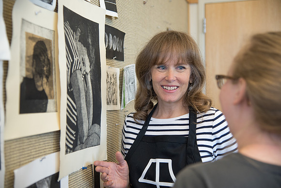 Art professor Carla Jimison speaks with a student about printmaking. 2017