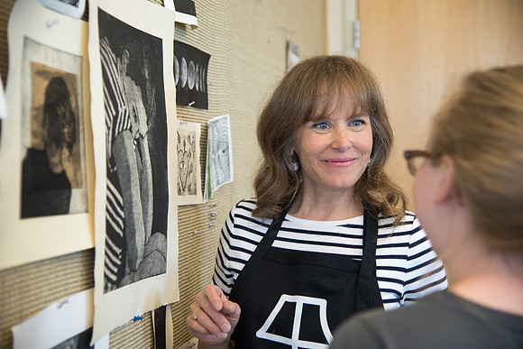 Art professor Carla Jimison speaks with a student about printmaking. 2017