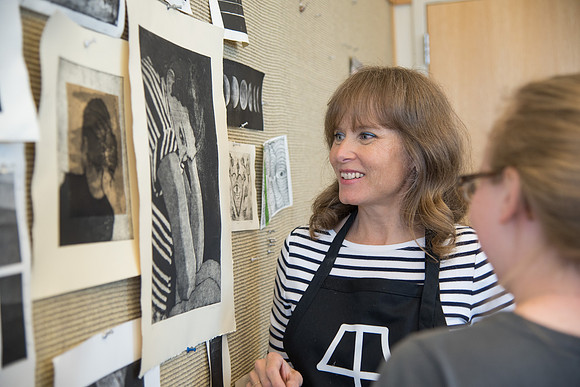 Art professor Carla Jimison speaks with a student about printmaking. 2017