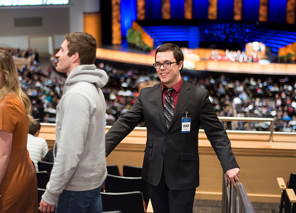 An usher helps devotional attendees find their seating.