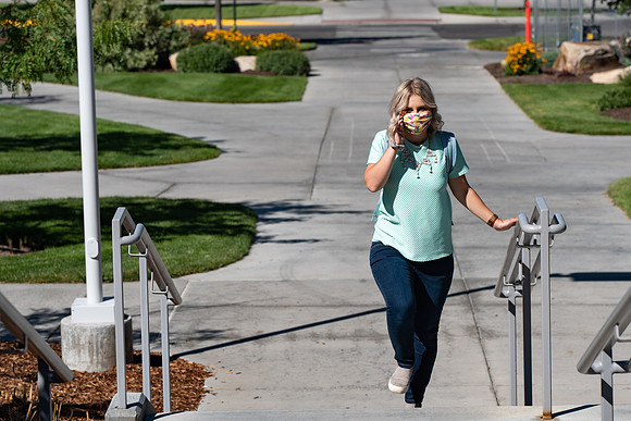 Examples of students staying safe and healthy during the COVID-19 pandemic by social distancing, following pathway arrows, and wearing face masks.