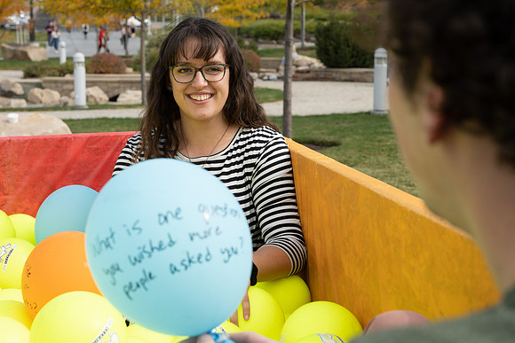 Students who volunteer to participate sit in the ball pit and ask each other questions which are found on the balloons. Video is being produced for Student Living.