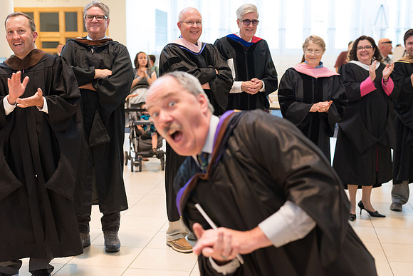 Faculty applauds students as they enter Commencement