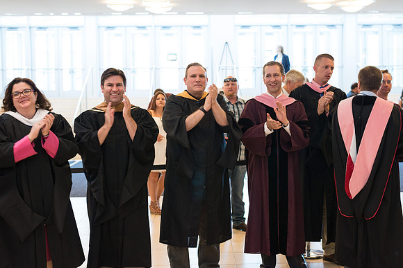 Faculty applauds students as they enter Commencement