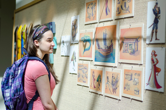 An art student looks at work done by her peers.