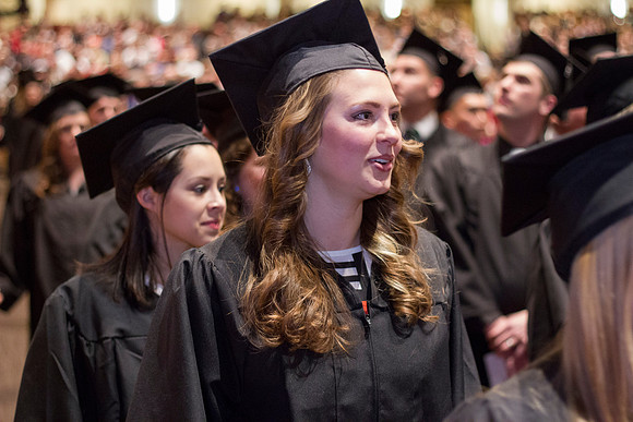 A 2014 Winter graduate smiles as she walks into the i-Center during the Commencement Ceremony.