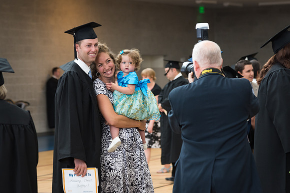 Mike Lewis, photographer for University Relations, photographs a Pathway Graduate and his family. 2017