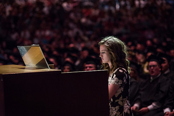 A woman plays the piano at the convocation for Business and Communications graduates. 2017