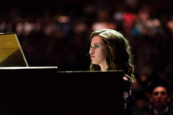 A woman plays the piano at the convocation for Business and Communications graduates. 2017