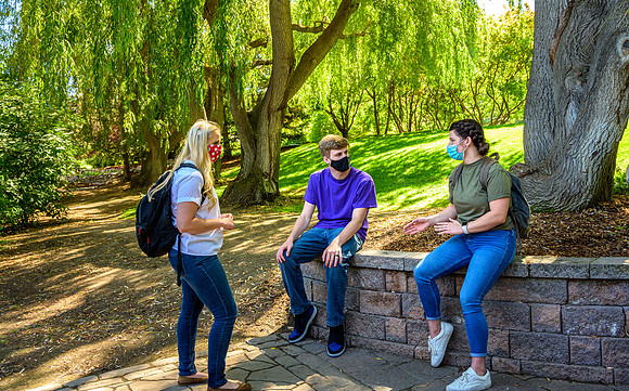Student volunteers show the way to stay safe during this COVID 19 pandemic by social distancing, following pathway arrows and proper wearing of masks .