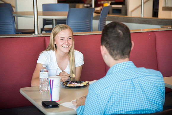 Two students share conversation over breakfast.