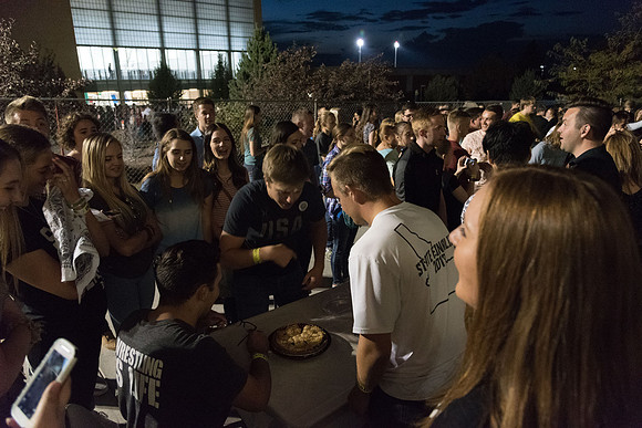 Students participate in a pie eating contest. Each pie is to be eaten by a team of three students who can only use their mouths to eat pies.