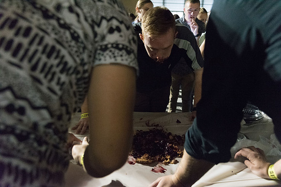 Students participate in a pie eating contest. Each pie is to be eaten by a team of three students who can only use their mouths to eat pies.