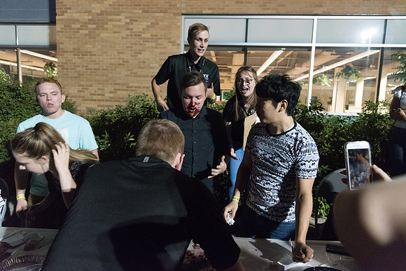 Students participate in a pie eating contest. Each pie is to be eaten by a team of three students who can only use their mouths to eat pies.