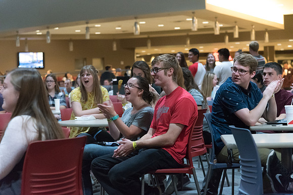 Students cheer for their friends and other who perform on the stage in the Crossroads.