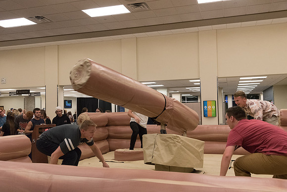 Students stand on inflatable platforms and try not to get knocked over by a spinning arm. They must jump and duck.