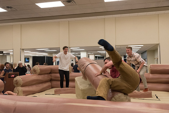 Students stand on inflatable platforms and try not to get knocked over by a spinning arm. They must jump and duck.