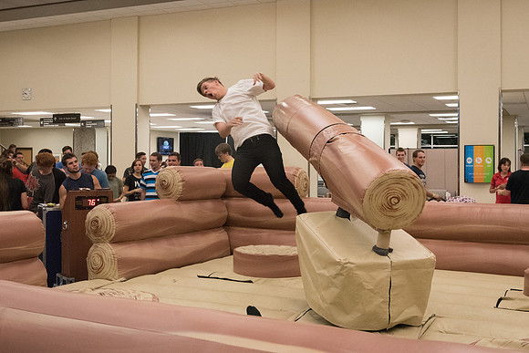 Students stand on inflatable platforms and try not to get knocked over by a spinning arm. They must jump and duck.