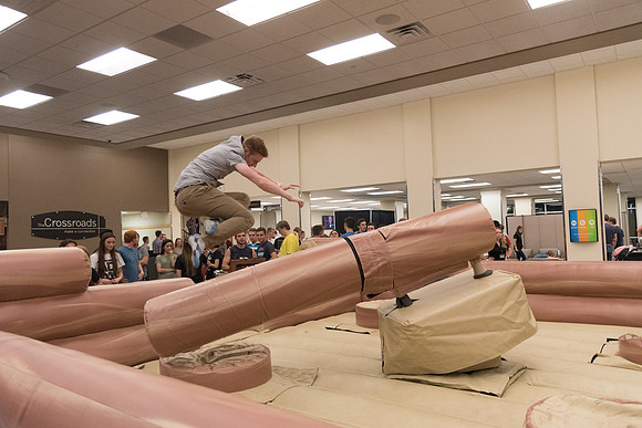 Students stand on inflatable platforms and try not to get knocked over by a spinning arm. They must jump and duck.