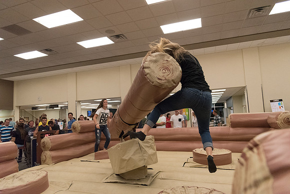 Students stand on inflatable platforms and try not to get knocked over by a spinning arm. They must jump and duck.