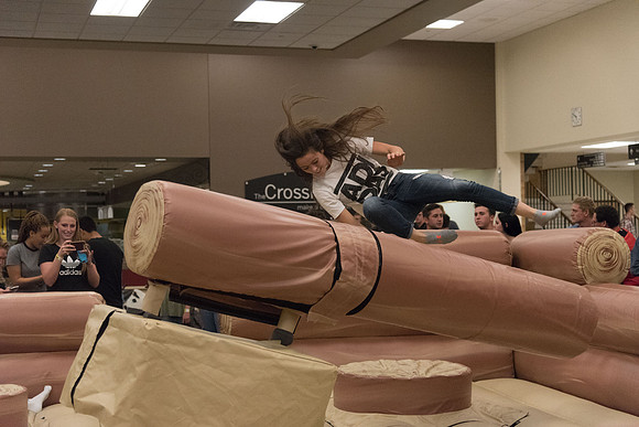 Students stand on inflatable platforms and try not to get knocked over by a spinning arm. They must jump and duck.