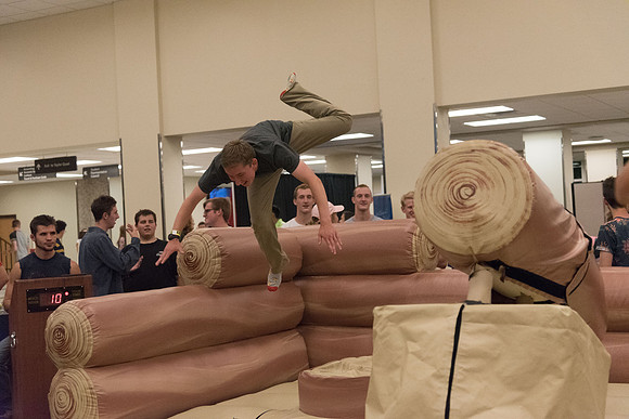 Students stand on inflatable platforms and try not to get knocked over by a spinning arm. They must jump and duck.