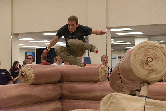 Students stand on inflatable platforms and try not to get knocked over by a spinning arm. They must jump and duck.