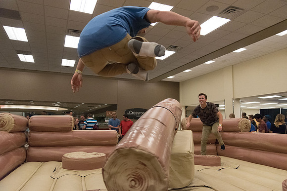 Students stand on inflatable platforms and try not to get knocked over by a spinning arm. They must jump and duck.