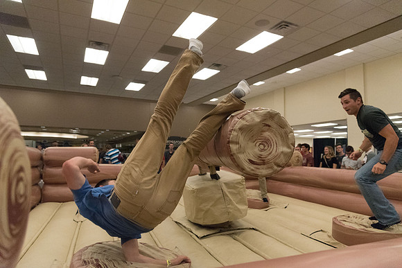Students stand on inflatable platforms and try not to get knocked over by a spinning arm. They must jump and duck.
