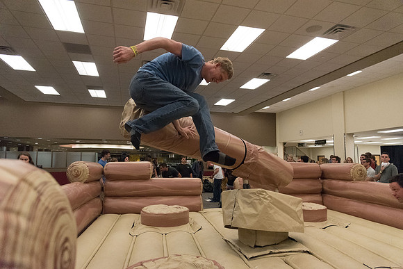 Students stand on inflatable platforms and try not to get knocked over by a spinning arm. They must jump and duck.