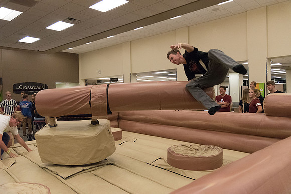 Students stand on inflatable platforms and try not to get knocked over by a spinning arm. They must jump and duck.
