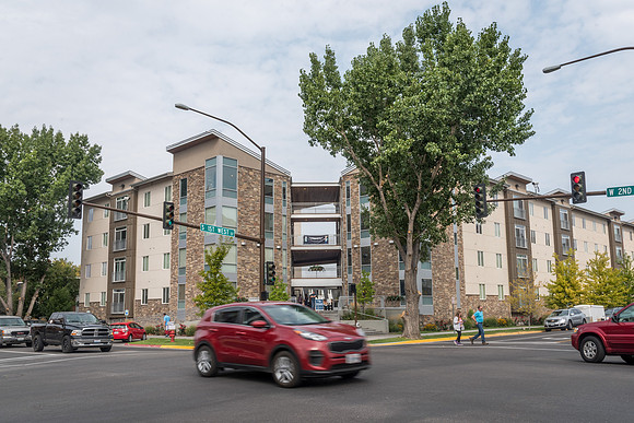 Cars drive in front of the Willows apartments.