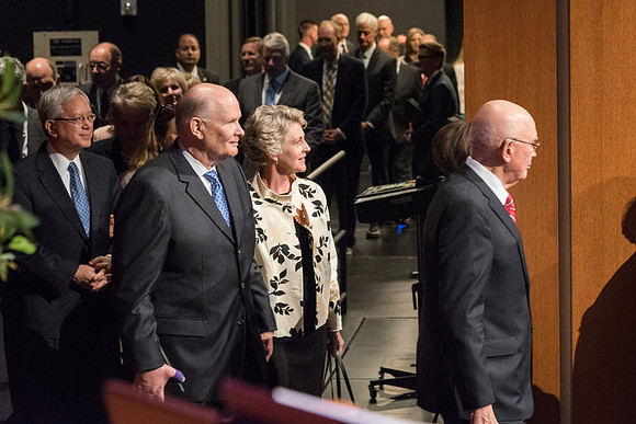 Elder Dale G. Renlund and Sister Renlund enter the BYU-I Center stage behind Elder Oaks.