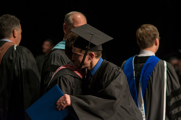Faculty members hand degrees to and congratualate graduates of the College of Performing and Visual Arts.