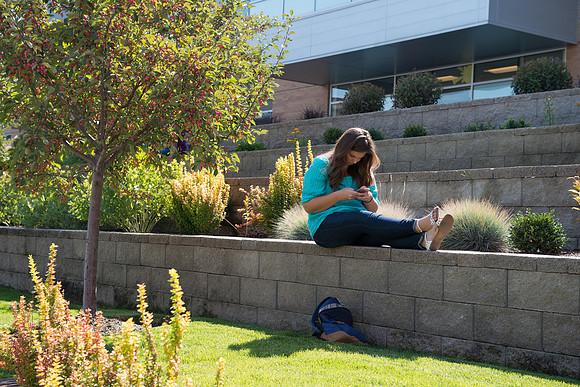 A student passes time between classes outside the MC Building, on the first day of school.