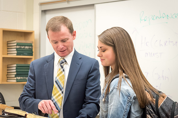 Brother Taylor, of the Religion Department, shares a scripture with a student. 2017