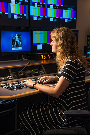 McKenzie Marcum sitting at the controls in the camera control room in the BYU-Idaho Center.