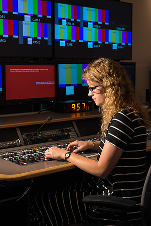 McKenzie Marcum sitting at the controls in the camera control room in the BYU-Idaho Center.