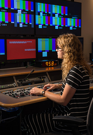 McKenzie Marcum sitting at the controls in the camera control room in the BYU-Idaho Center.