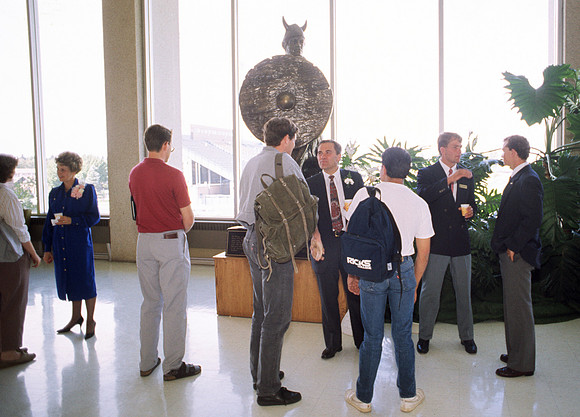 1989, President Steven D. Bennion, President of Ricks College greets students in the foyer of the Hart Building.
