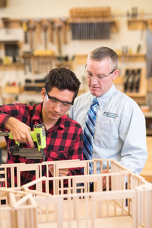 Student works in the Woodshop alongside his teacher, Brother Jensen.