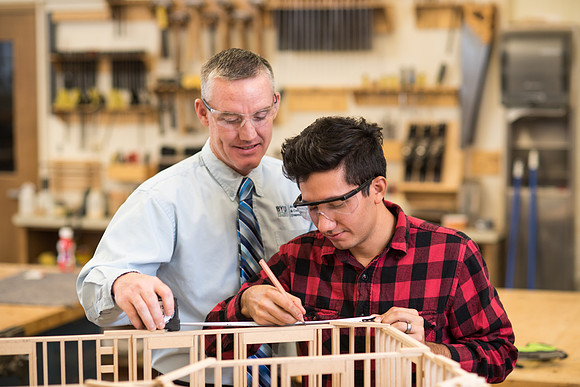 Student works in the Woodshop alongside his teacher, Brother Jensen.
