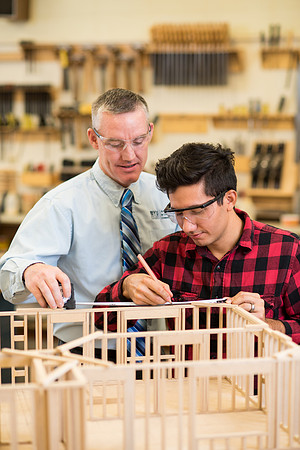 Student works in the Woodshop alongside his teacher, Brother Jensen.