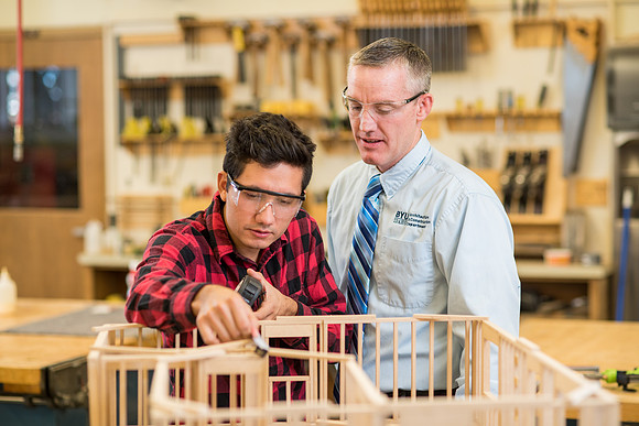 Student works in the Woodshop alongside his teacher, Brother Jensen.