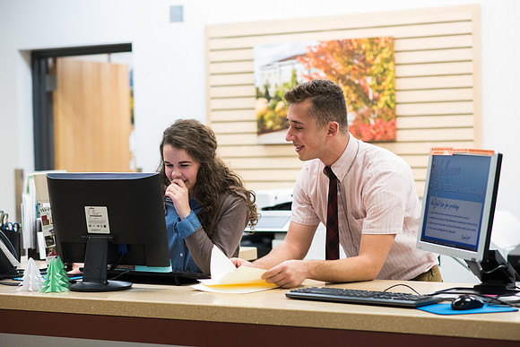 Students work together to help students print assignments at the Express Print and Copy.